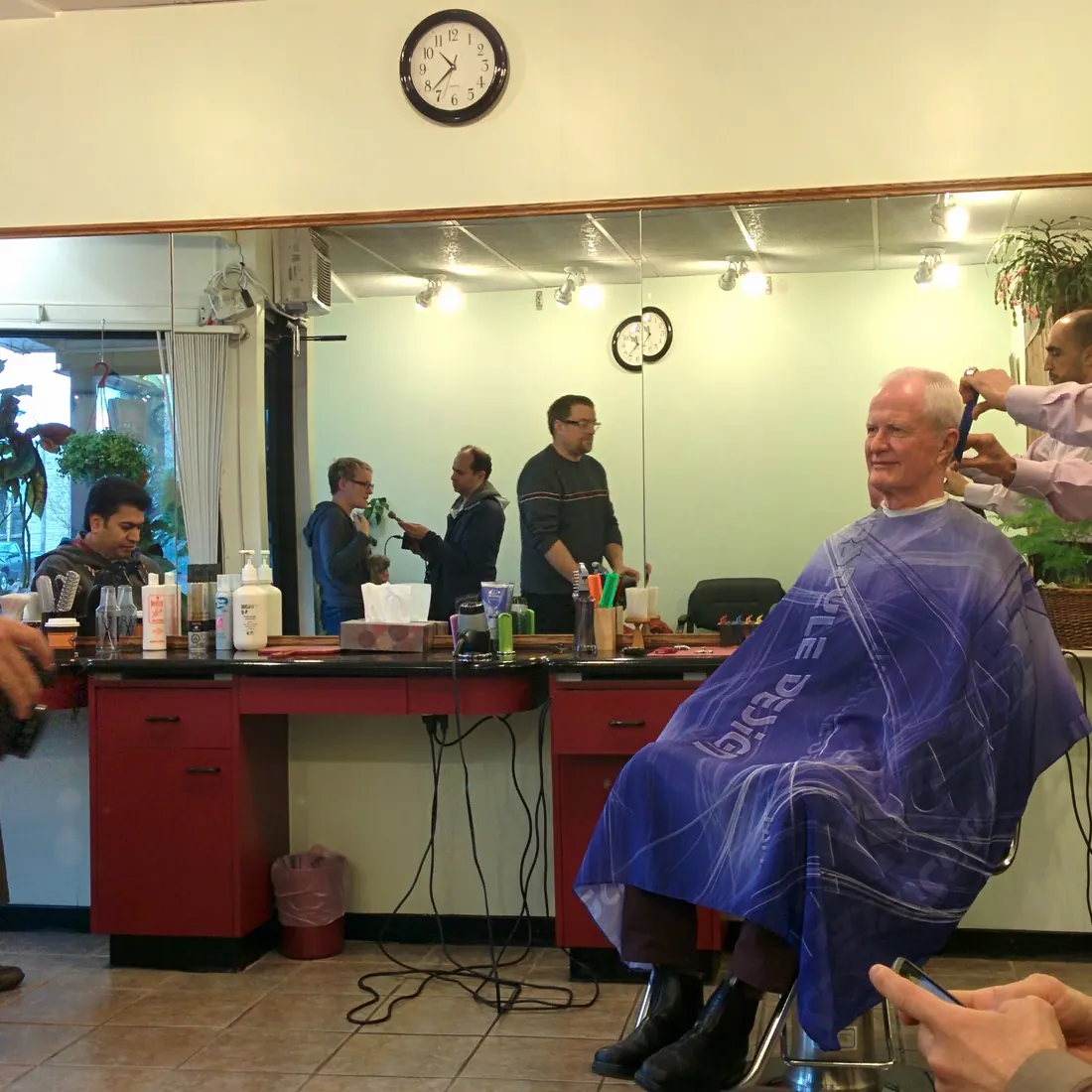 Ali giving a customer a haircut inside Opus Barber Shop